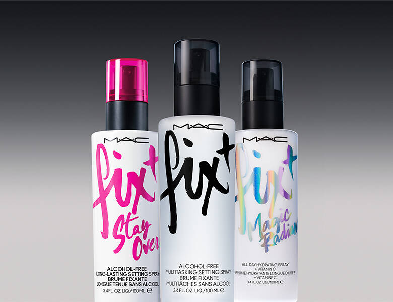 Her ses en mørkegrå baggrund med tre forskellige setting sprays fra MAC.