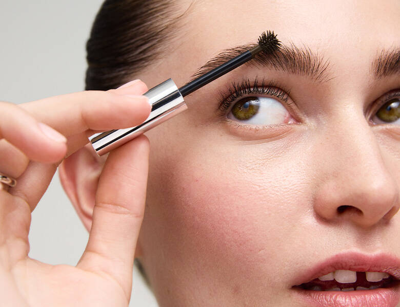 Her ses en kvinde, som bruger et Xlash produkt i sit øjenbryn. 