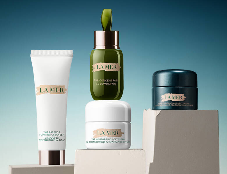 Her ses fire produkter op en sandfarvet holder med en blå baggrund. 