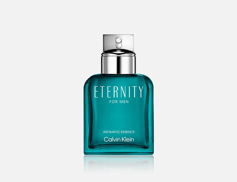 Her ses et billede af en parfumeflakon placeret centralt mod en lys baggrund. På flakonen står teksten “ETERNITY FOR MEN”, “AROMATIC ESSENCE” og “Calvin Klein”. Flakonen er i en turkis nuance med gennemsigtig overflade og har et sølvfarvet låg.
