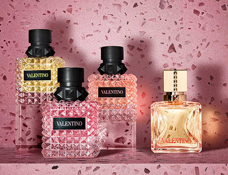 Her ses fire Valentino parfumer til kvinder på en lyserød baggrund. 