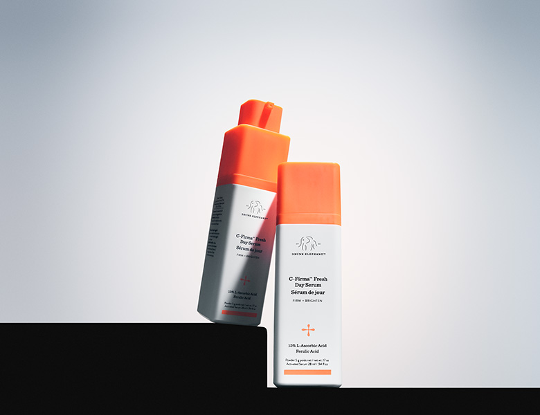 Her ses Drunk Elephant serum i hvid og orange emballage på en lys baggrund.