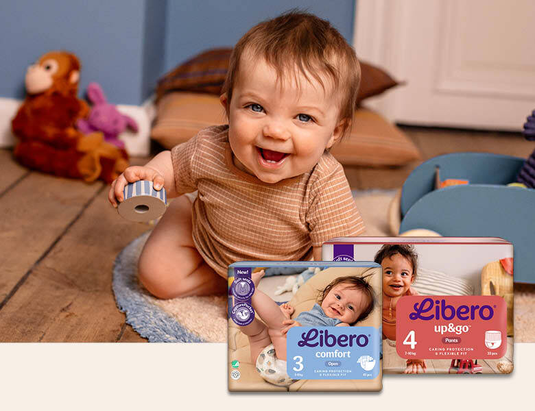 Her ses en legende baby på et legeværelse. I nederste højre hjørne ses to slags Libero bleer.