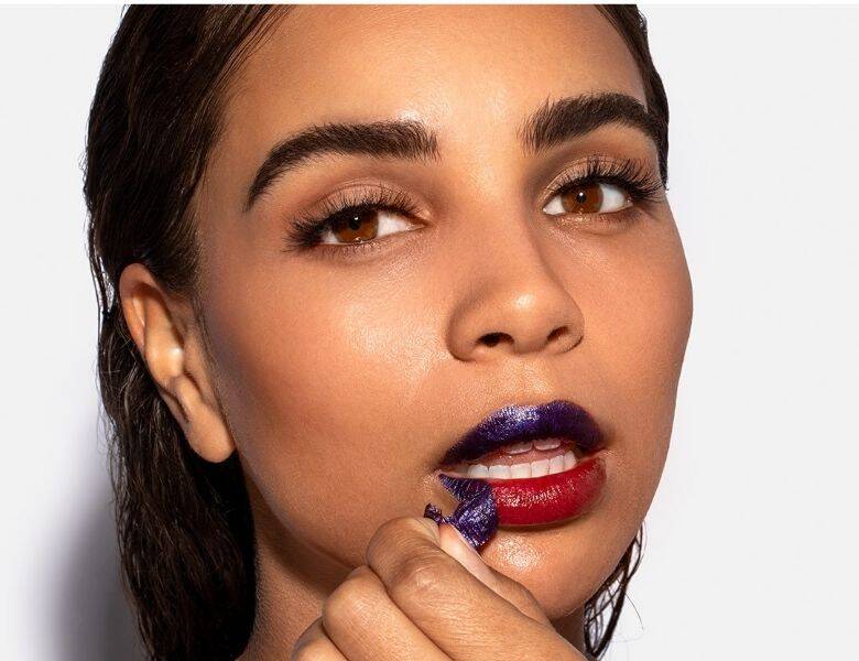 Her ses en kvinde, som er ved at pille en lip stain af.