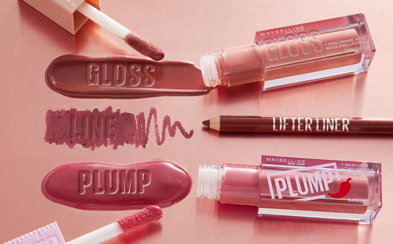 Her ses en lyserød baggrund med forskellige lyserøde og røde læbeprodukter fra Maybelline. 