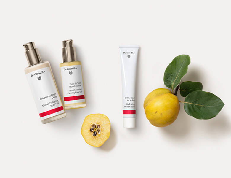 Her ses en hvid baggrund med tre produkter, som hver har en rød stribe. Ved siden ses to gule frugter. 