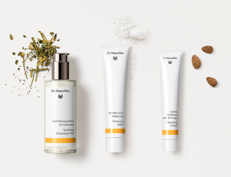 Her ses en hvid baggrund med tre hvide produkter, som alle har en gul stribe. Ud fra hvert produkt ligger nogle ingredienser. 