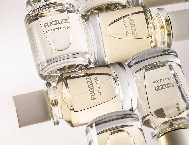 Her ses en hvid baggrund med flere lyse Fugazzi parfumer, som ligger ned. 