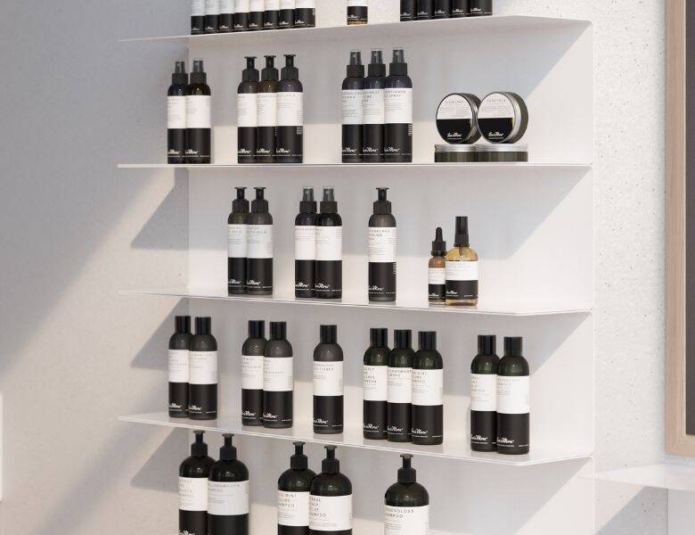 Her ses en hvid hylde med en hel masse Less Is More produkter. 