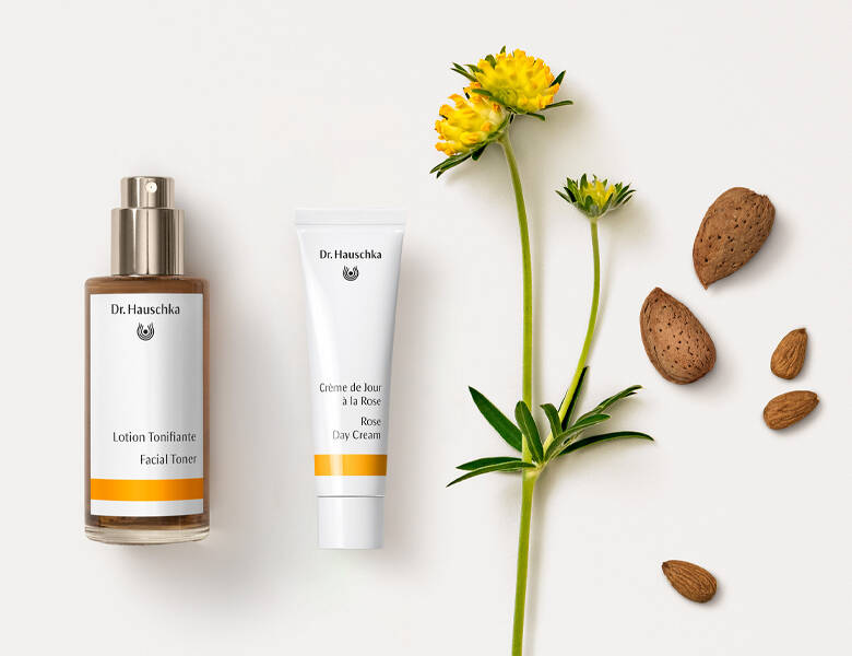 Her ses to produkter til venstre og en gul blomst samt nogle nødder i højre. 