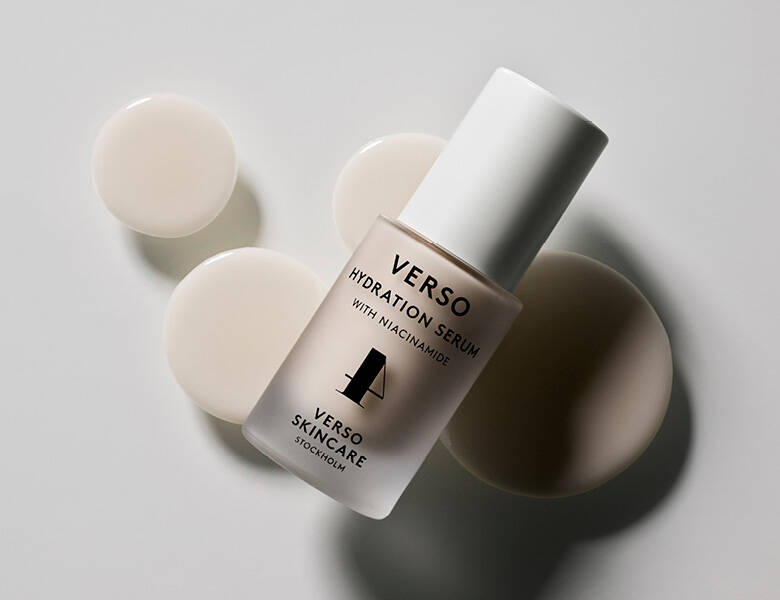 Her ses en serum fra Verso. Den ligger på nogle beige prikker og en lys baggrund.