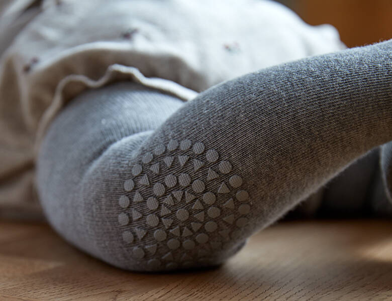 Her ses et close-up billede af et par grå strømpebukser. 