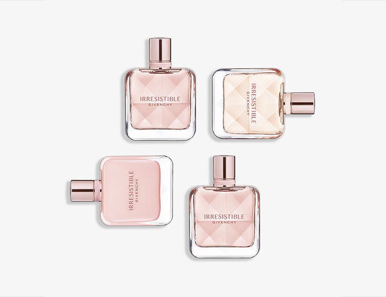 Her ses fire lyserøde Givenchy parfumer liggende på en lysegrå baggrund.