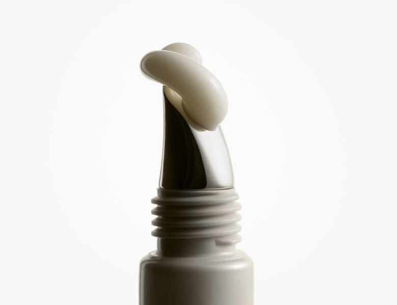 Her ses et close-up billede af et produkt, hvor cremen kommer ud af tuben. Baggrunden er hvid. 