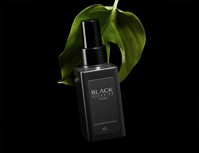 Her ses en sort baggrund med et grønt blad og et sort produkt. 