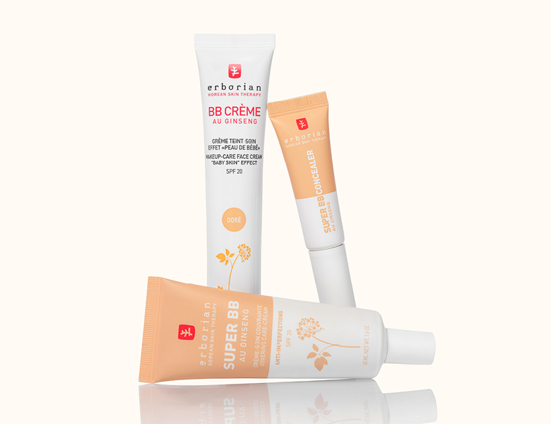 Her ses Erborian BB creme og concealer i beige og hvid emballage på en lys baggrund.