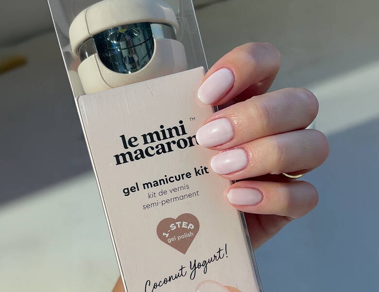 Her ses en hånd, md neutral neglelak. Hånden holder et Le Mini Macaron gel sæt. 