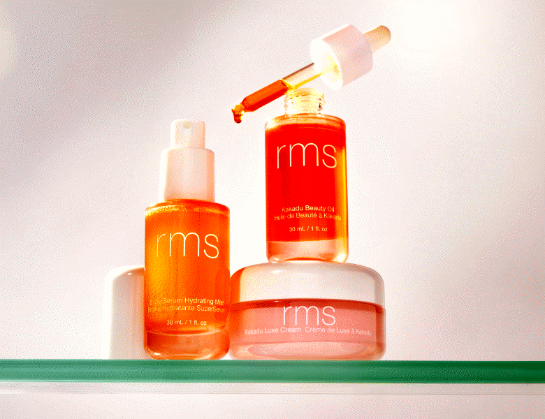 Her ses tre orange RMS hudpleje produkter på en hvid baggrund. To af produkterne står på hinanden. 