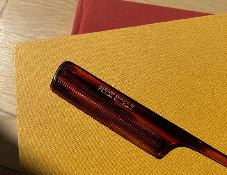 Her ses en brun kam på en gul bog. 