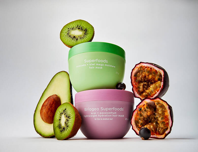 Her ses en lysegrå baggrund med to produkter - et grønt og et pink. Omkring er forskellige frugter. 