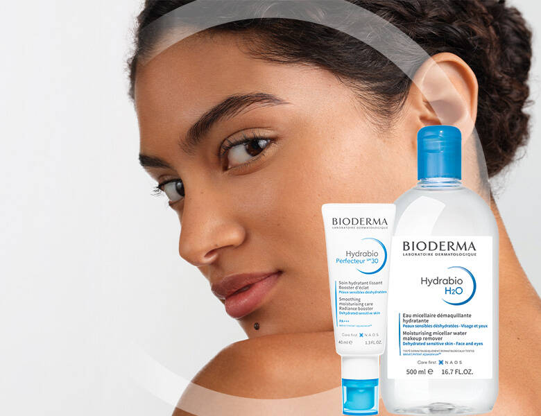 Her ses ansigtet af en kvinde med to BIODERMA produkter foran sig.
