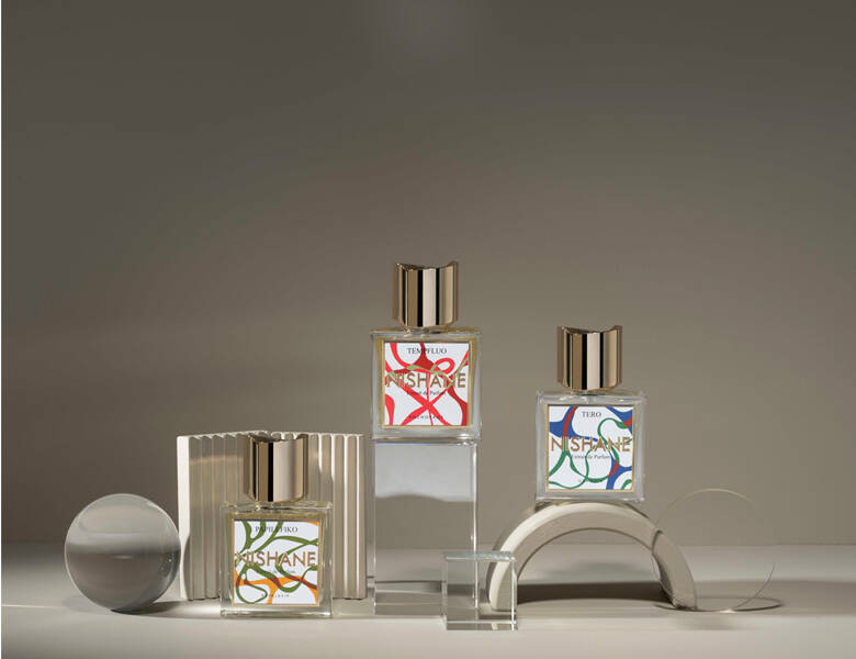 Her ses flere NISHANE parfumer på forskelligformede holder. Baggrunden er grå.