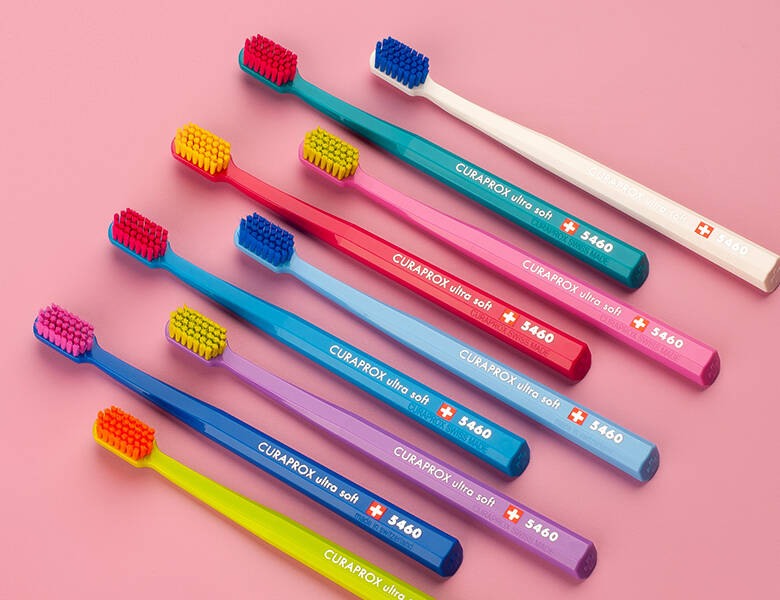 Her ses farverige tandbørster på en pink baggrund. 