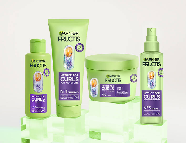 Her ses en lys baggrund med fire grønne og lilla produkter. 