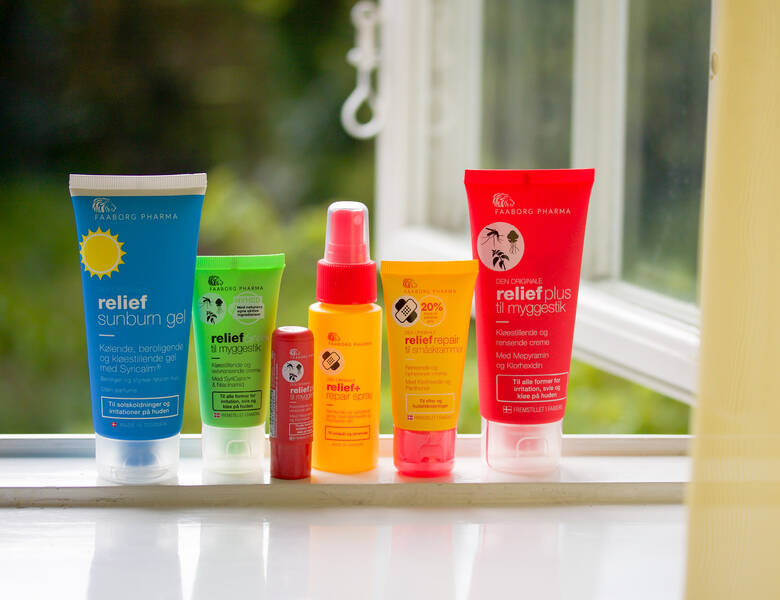 Her ses seks forskellige farverige Faaborg Pharma produkter i en vinduskarm. 