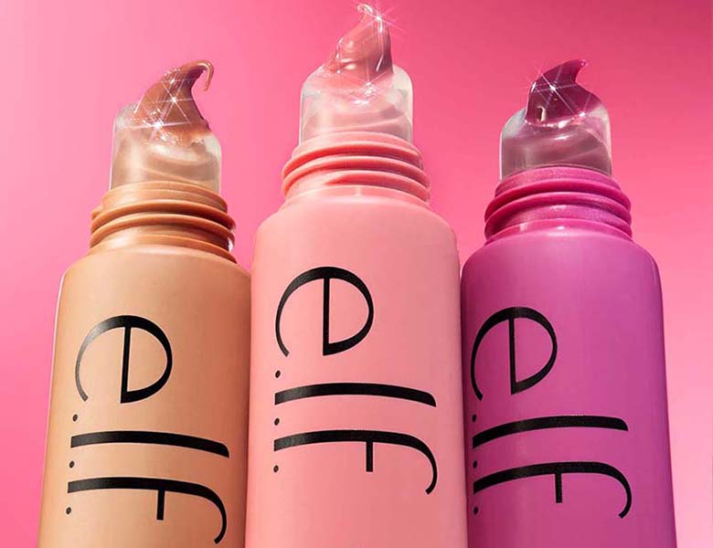 Her ses et billede med flere læbeprodukter fra e.l.f. placeret mod en pink baggrund. Produkterne er i nude, lyserøde og lilla nuancer med store “e.l.f.”-logoer på emballagen.