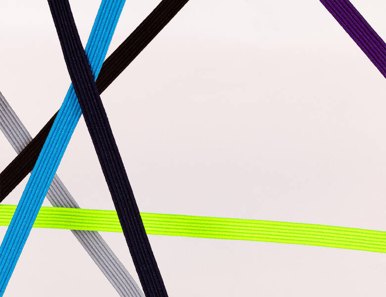 Her ses en lys baggrund med forskellige farvede snørebånd på kryds og tværs. 