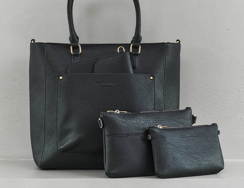 Her ses en serie af flere tasker og punge i forskellige størrelser. Alle er i sort læder og på en grå baggrund. 