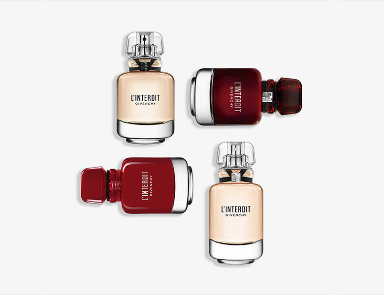Her ses fire Givenchy parfumer liggende på en lysegrå baggrund - to af dem er røde og de to andre er lys laksefarvet.