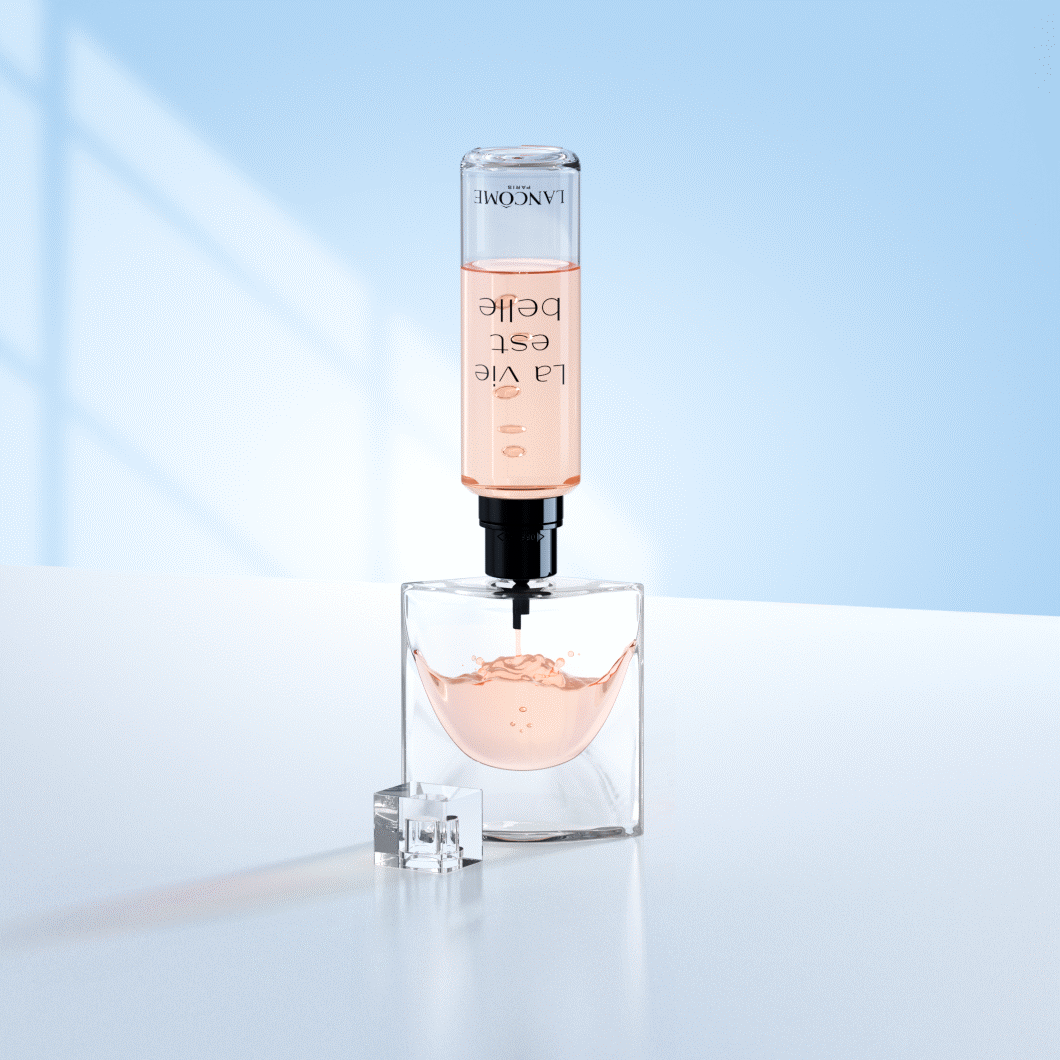 En parfumeflaske fra Lancôme står på en lys overflade foran en blød lyseblå baggrund. Oven på flasken er en refillbeholder monteret, som fylder parfumen op med en lyserød væske. Flaskens låg ligger ved siden af. Billedet fremhæver et elegant og moderne refill-system til luksusparfume.