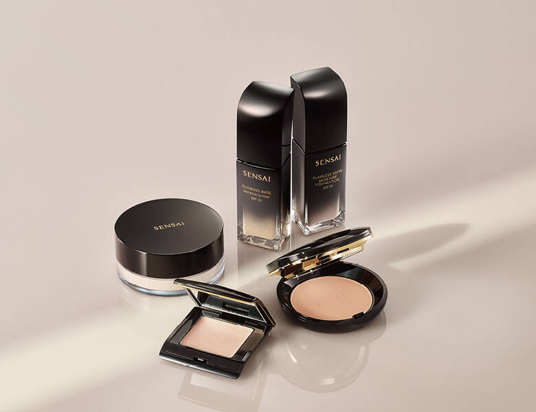 Her ses en lys baggrund med flere sorte makeupprodukter. 