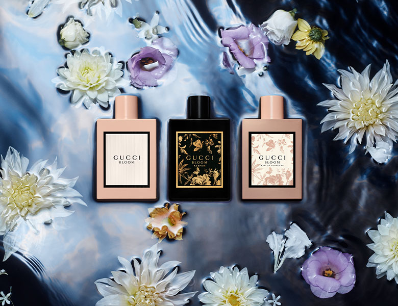 Her ses en mørk baggrund med tre Gucci parfumer - to lyserøde og en sort. 