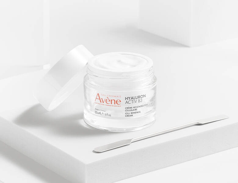 Her ses et Avène produkt med låget halvt af. Baggrunden er hvid.