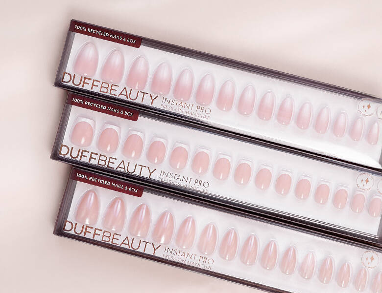 Her ses nogle forskellige lyserøde negle fra DUFFBEAUTY på en lys lyserød baggrund. 