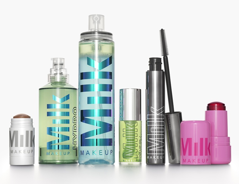 Her ses et billede med flere makeup-produkter fra Milk Makeup placeret side om side mod en lys baggrund. På produkterne står teksten “Milk Makeup” og “Hydro”. Produkterne inkluderer blandt andet spray, mascara og sticks i grønne, blå, sorte og pink emballager.