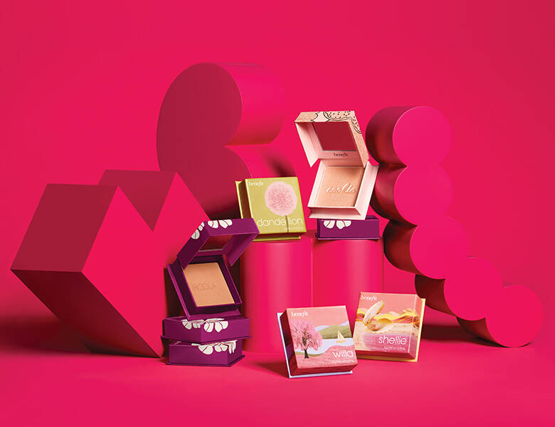 Her ses en rød baggrund med røde figurer, som flere produkter til ansigtet står op af. 