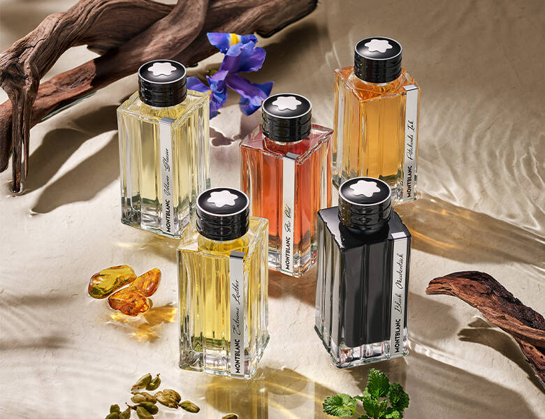 Her ses en masse forskellig farvede parfumer i noget klart vand med planter. 