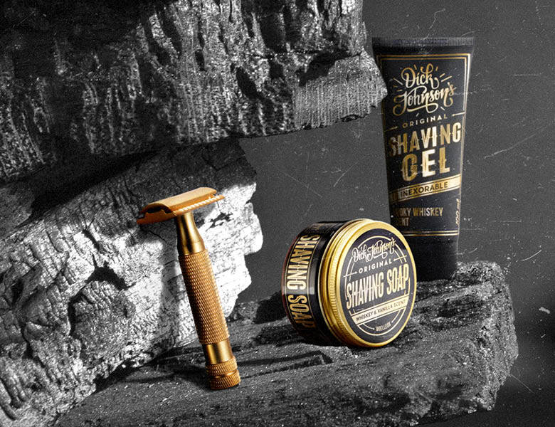 Her ses en mørk grotte med tre Dick Johnson produkter til barbering. 