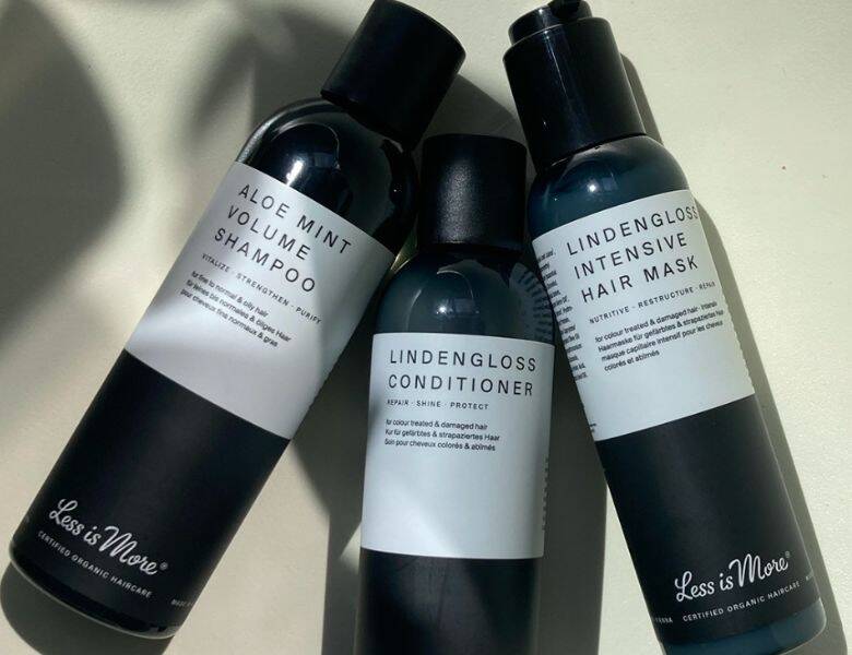 Her ses tre mørke Less Is More produkter liggende på en lys baggrund. 