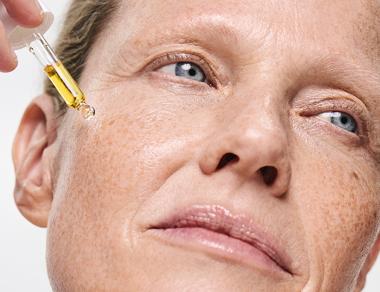 Her ses en lys baggrund med to glashylder, hvorpå der står en masse produkter. 