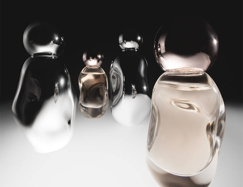 Her ses en sort og hvid baggrund med fire parfumer. 