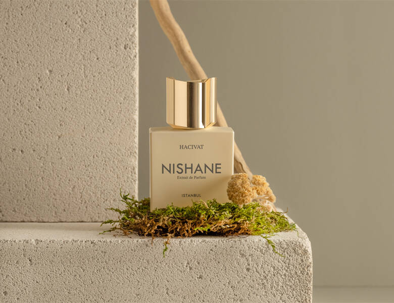 Her ses en Nishane parfume på noget mos og sandfarvede sten.