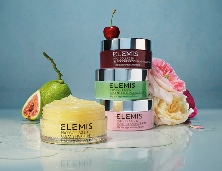 Her ses ELEMIS renseprodukter – cleansing balms i forskellige farver sammen med frugt og blomster på en lys baggrund.