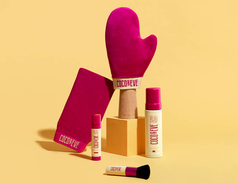 Her ses en gul baggrund med forskellige gule og røde Coco & Eve produkter på.