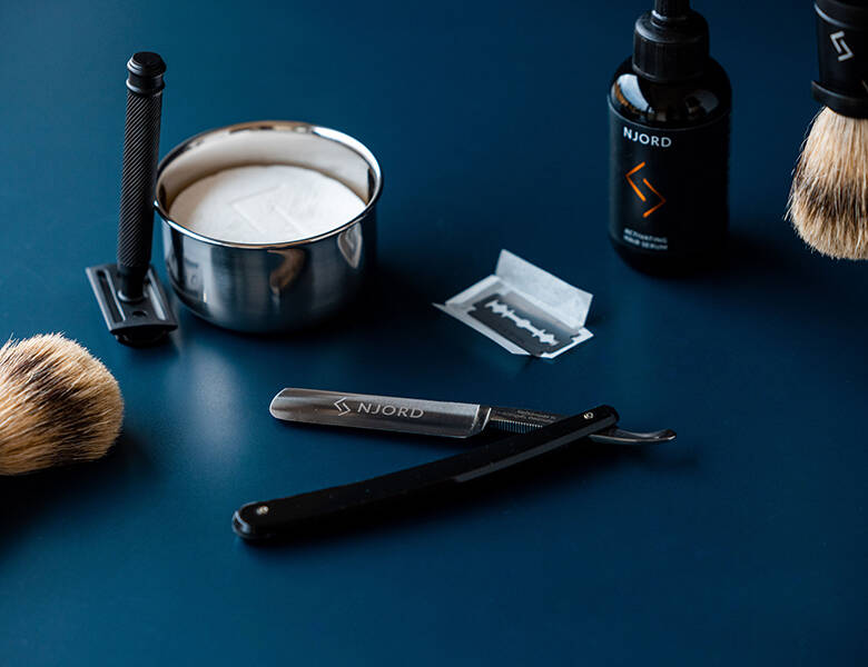 Her ses Njord barberingsgrej på en mørkeblå baggrund. 