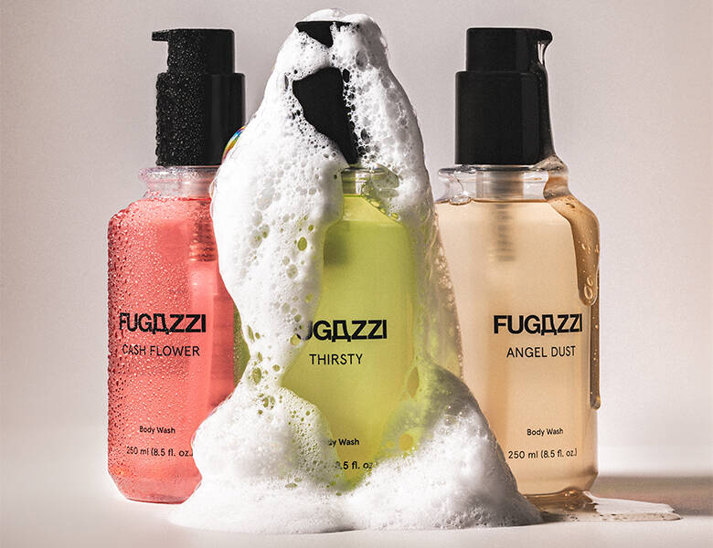 Her ses en hvid baggrund med tre Fugazzi sæber i henholdsvis lyserødm grøn og beige. Der er sæbeskum omkring dem. 